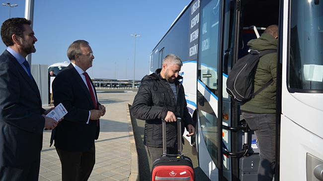 El consejero Patricio Valverde saluda a turistas que hacen uso de este servicio de autob&uacute;s existente en el aeropuerto.