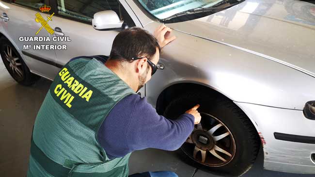 Un guardia civil revisa uno de los vehículos dañados Un guardia civil revisa uno de los vehículos dañados
