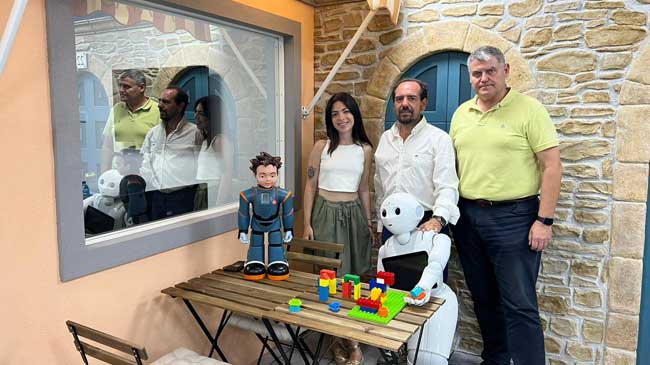 Gema Benedicto, Jos&eacute; Manuel Ferr&aacute;ndez y Eduardo Hurtado junto a los robots Milo y Pepper en el laboratorio que simula una cafeter&iacute;a