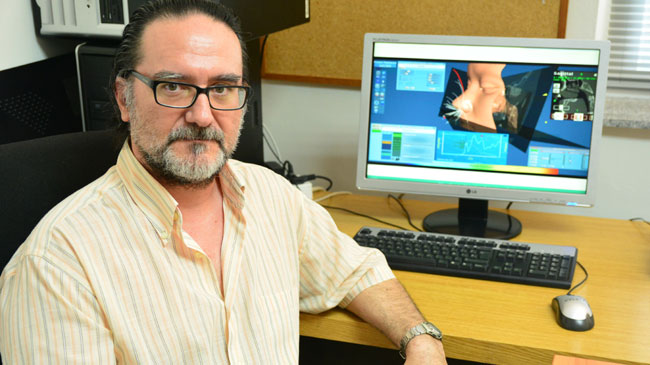 Manuel Burgos en su despacho de la UPCT, con la web de Flowgy en su ordenador