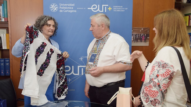 La rectora de la UPCT, Beatriz Miguel, con una prenda regional con la que le ha obsequiado el rector ucraniano