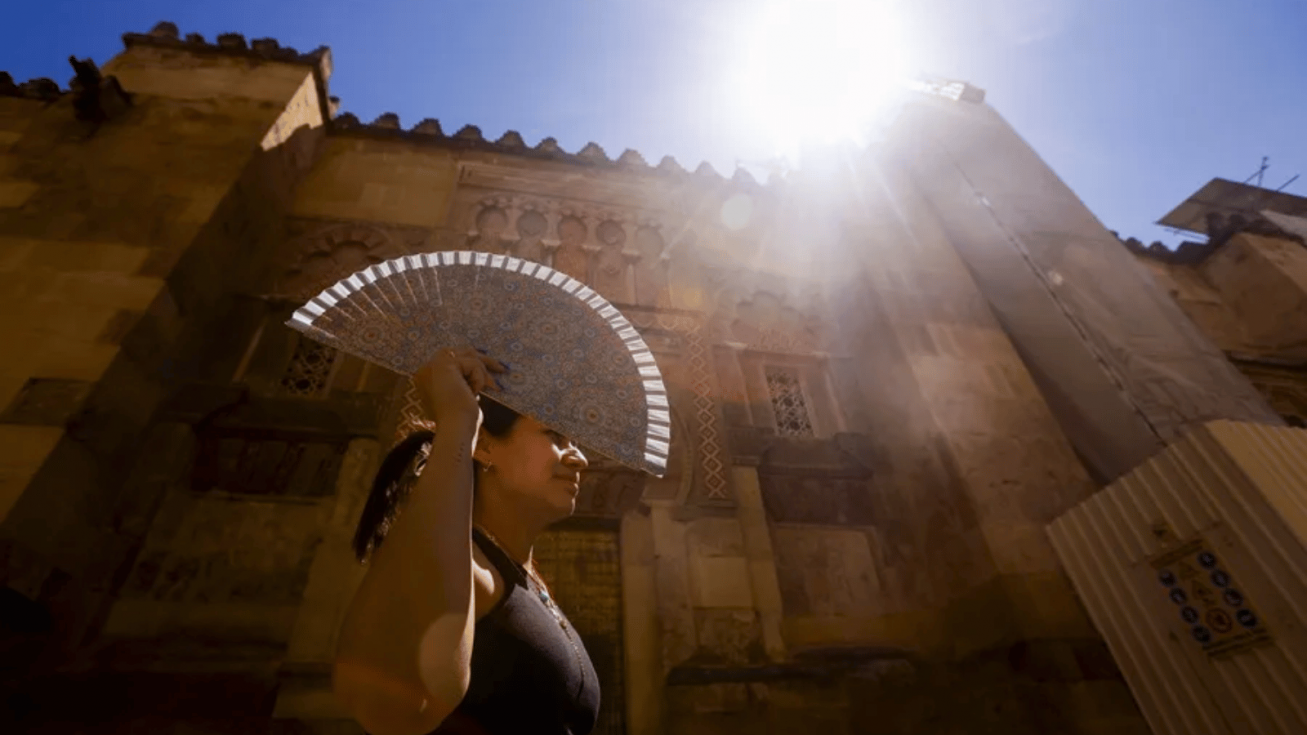 Una mujer se protege del sol con un abanico en C&oacute;rdoba. EFE/Salas