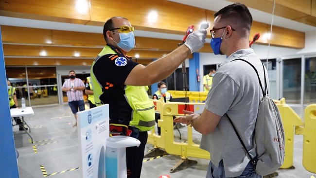 Un sanitario toma la temperatura a un asistente al festival "Live Mar Menor" celebrado en el Polideportivo Municipal de Los Alc&aacute;zares, en Murcia, siguiendo todos los protocolos de seguridad sanitaria. EFE/Juan Carlos Caval