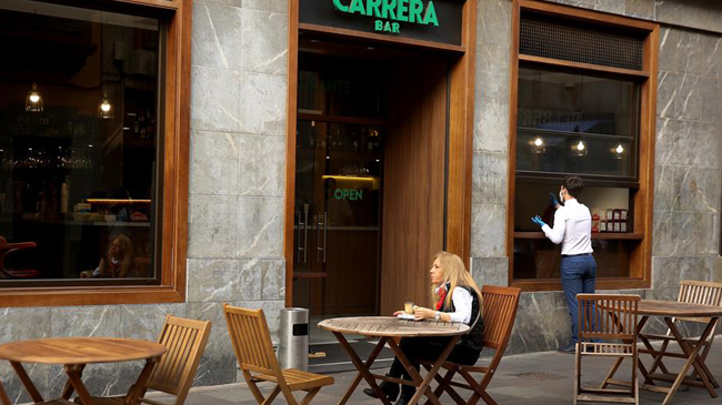 Una mujer desayuna en una terraza de un bar de La Laguna, en Tenerife. EFE/ Crist&oacute;bal Garc&iacute;a/Archivo