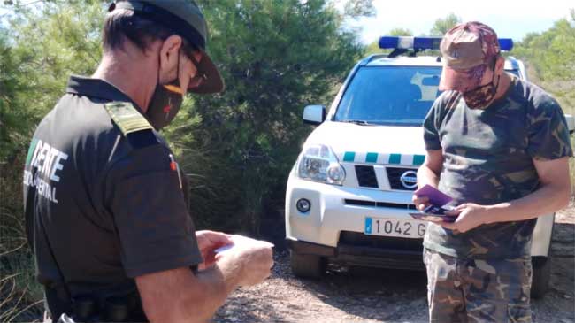 Un agente medioambiental comprueba la documentaci&oacute;n de un cazador