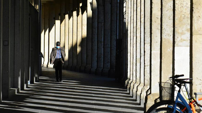 Un hombre camina por los soportales de la Calle Mayor de Palencia en el primer d&iacute;a de confinamiento perimetral de la ciudad, por el alto &iacute;ndice de contagios de Covid. EFE/ A. Alvarez