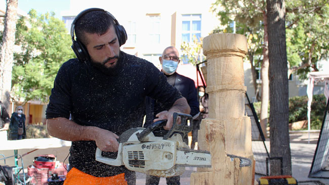 Un artesano elabora esculturas en madera en el Mercado de El Lago